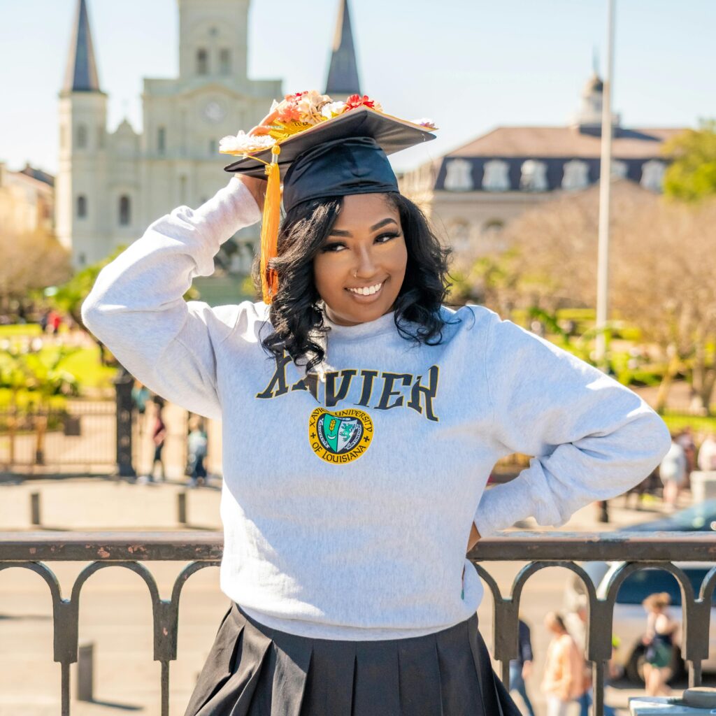 Young woman celebrating her graduation near St. Louis Cathedral in New Orleans.